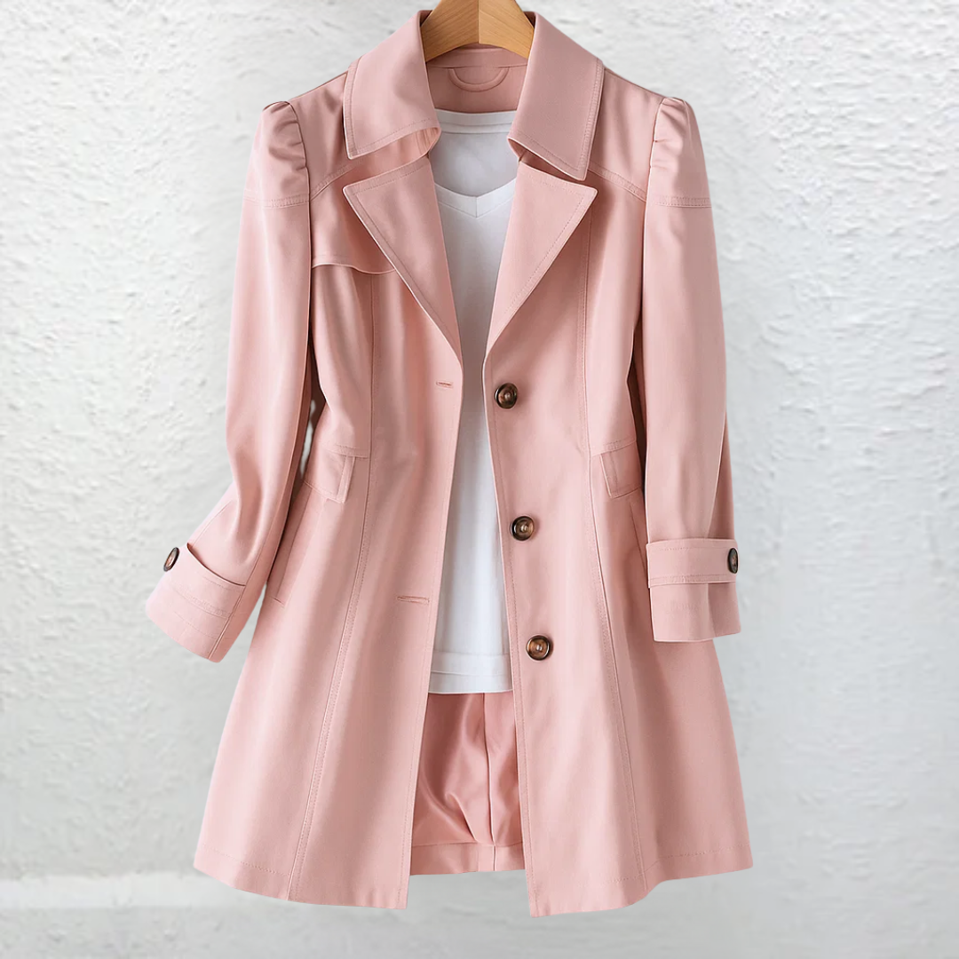 Pink coat on a hanger, set against a textured white wall.