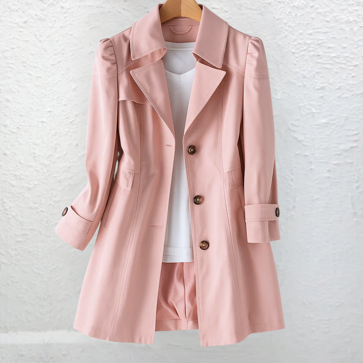 Pink coat on a hanger, set against a textured white wall.