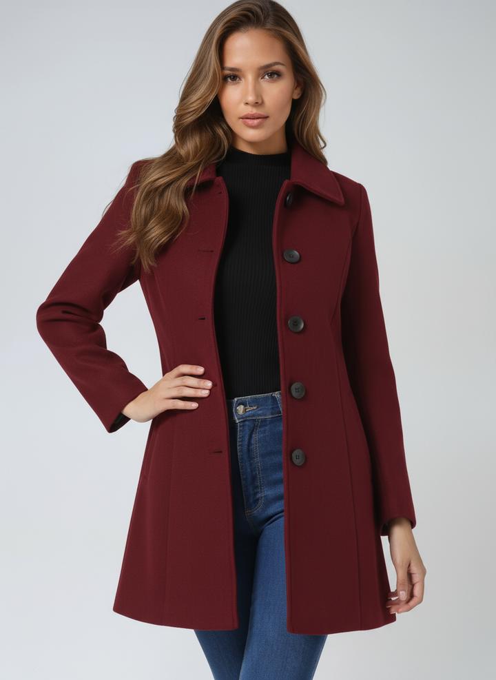 Maroon elegant coat worn by a person, hand on hip, in a light studio setting.