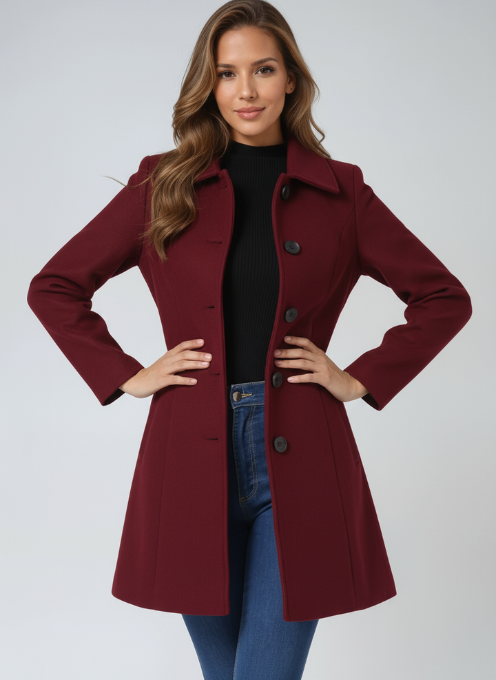 Front view of maroon elegant coat worn by a person with hands on hips.