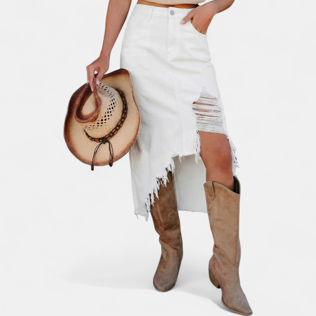 White distressed high-waist denim maxi skirt with a cowboy hat and tan boots in a studio setting.