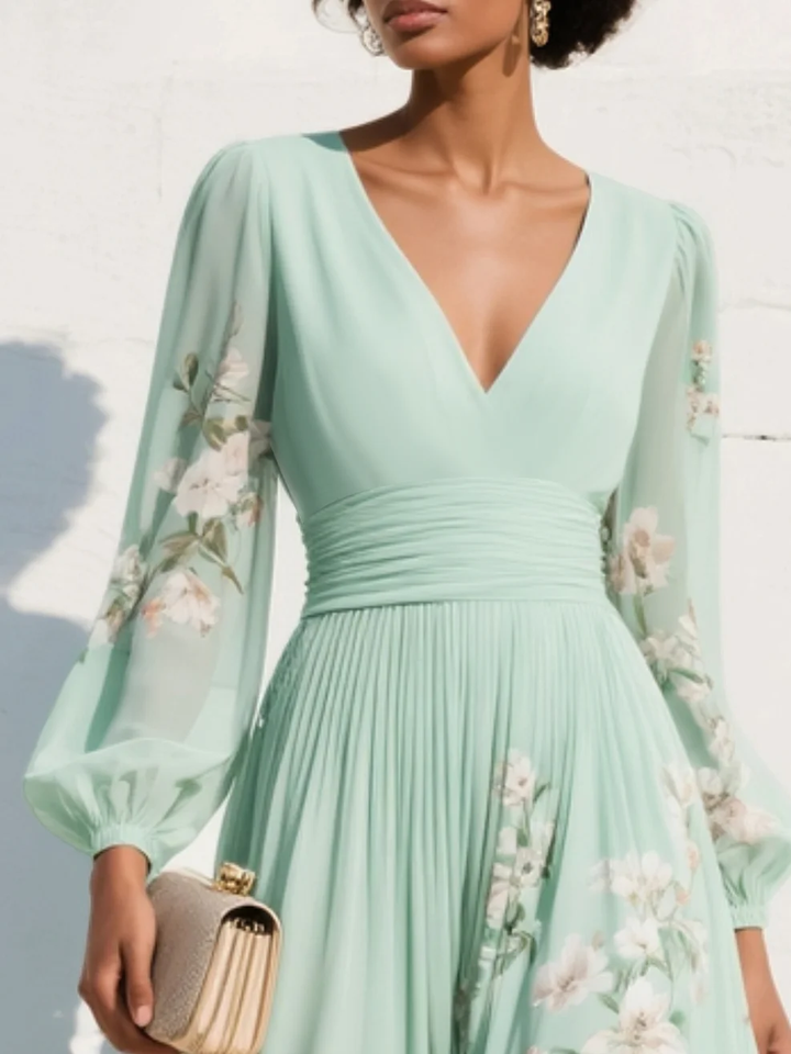 Close-up of light green floral midi dress with long sleeves, highlighting the bouquet pattern and V-neckline, with a clutch.