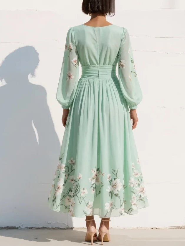 Back view of a light green floral midi dress with long sleeves, showing detailed floral patterns, worn by a woman in heels.