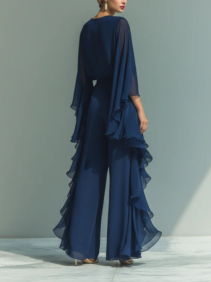 Back view of deep blue two-piece set with cascading layers and loose fit, worn with heels in a plain studio setting.