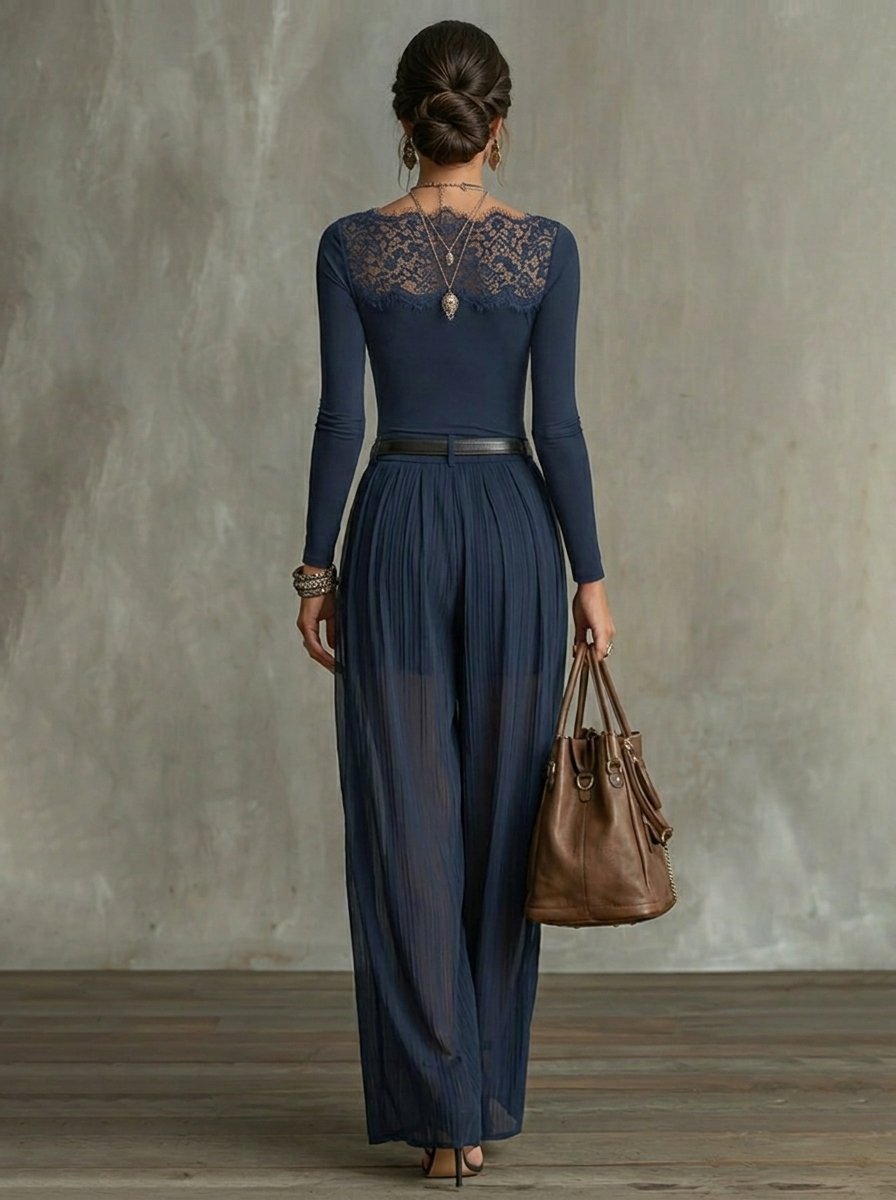 Back view of elegant navy blue outfit showcasing lace detailing and sheer wide-leg pants in a studio background.