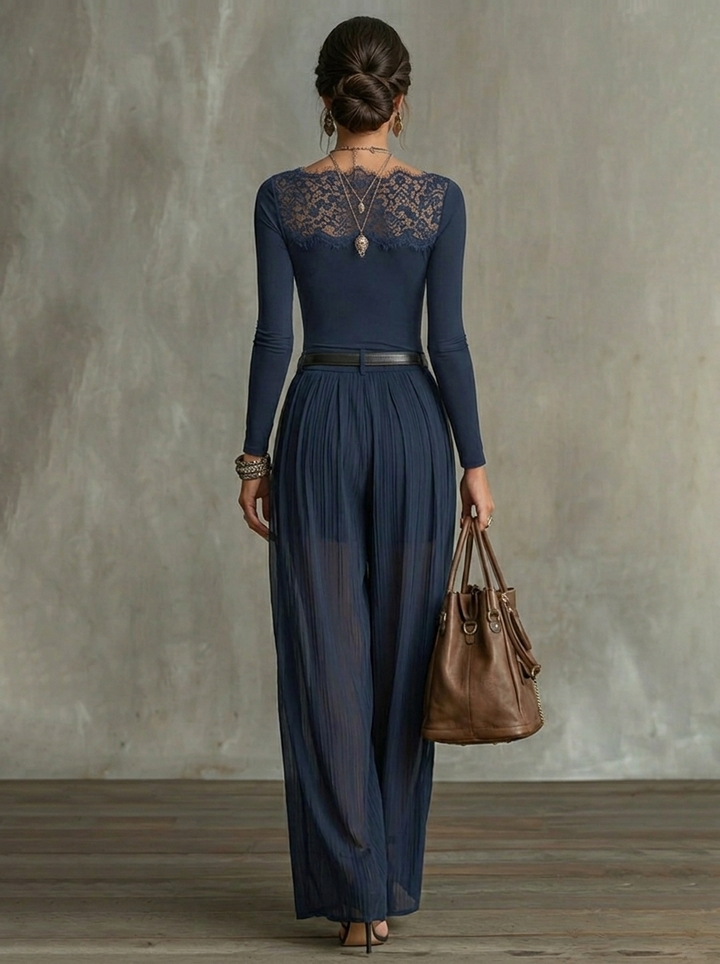 Back view of elegant navy blue outfit showcasing lace detailing and sheer wide-leg pants in a studio background.