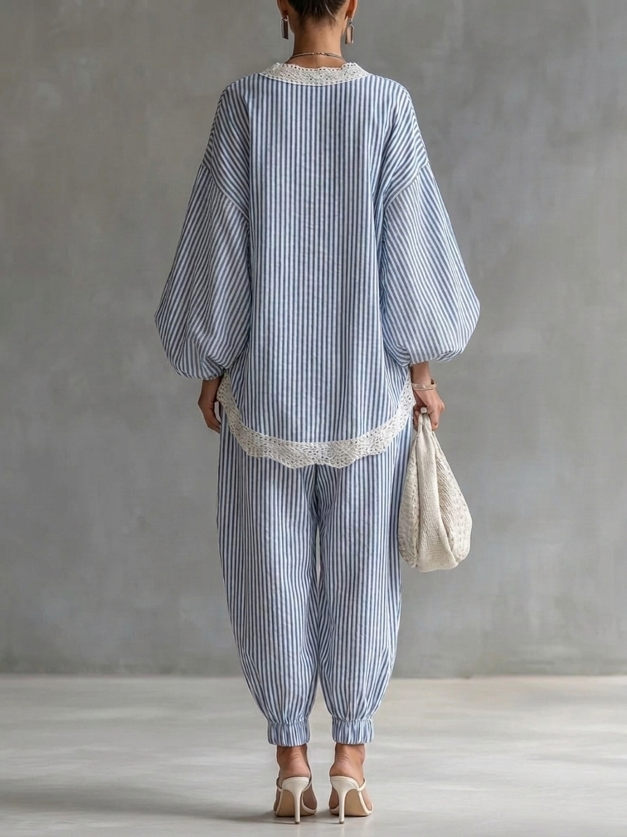 Back view of a blue and white striped two-piece set with lace trim, complemented by white heels and a woven bag, in a studio setting.