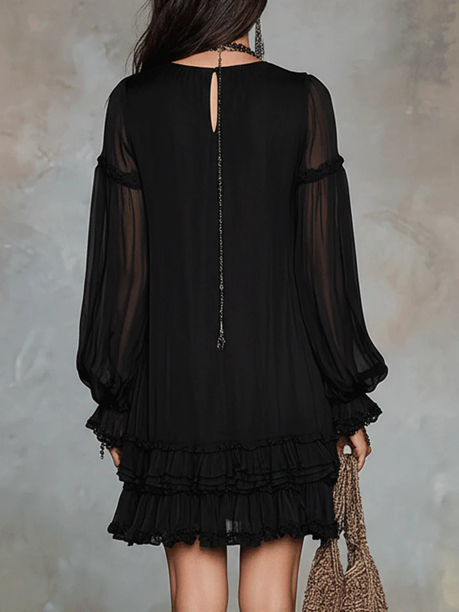 Back view of black mini dress with ruffled hem and voluminous sheer sleeves, set in a studio.