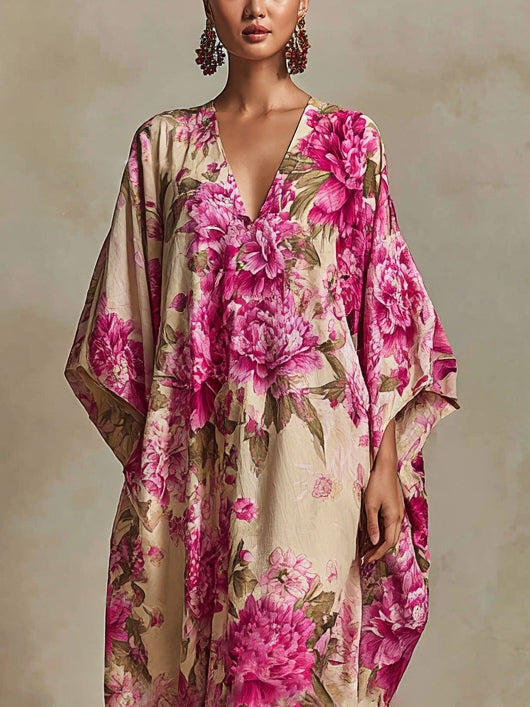 Close-up of maxi dress top, featuring bright pink floral design and flowing sleeves against a neutral, textured backdrop.