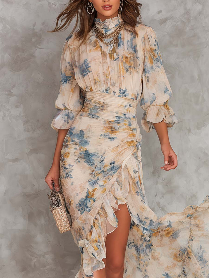 Model in floral maxi dress with ruffle details, intricate jewelry, and a textured gray background in a studio setting.