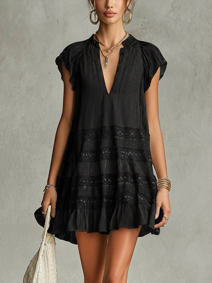 Black striped chiffon mini dress with lace trim and ruffles, modeled in a studio setting.