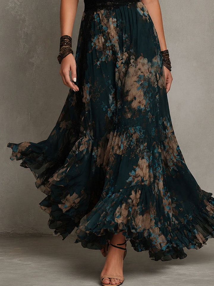 Close-up of lower half of dark floral maxi dress with ruffled hem, worn by model walking in a studio setting.