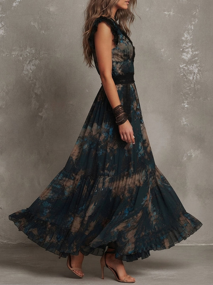Side view of maxi dress with dark floral motif and black lace trim, worn by model in a studio with gray backdrop.