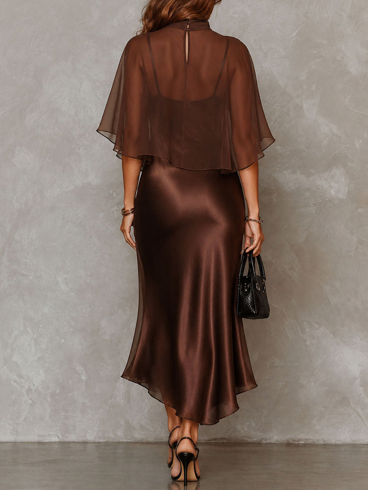 Back view of a brown midi dress with a sheer overlay. Studio background.