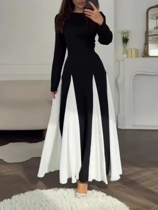 Full view of a stylish black and white colorblock dress in an elegant indoor setting with decorative elements.