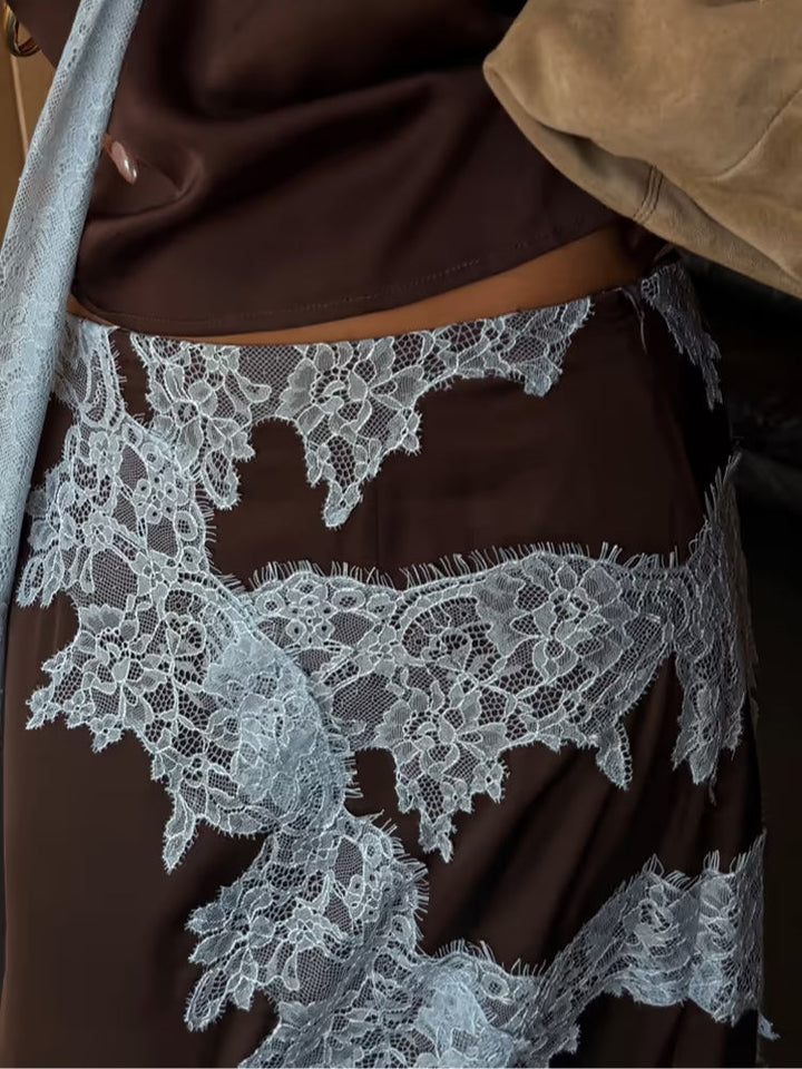 Close-up of lace detailing on brown suit with intricate blue lace pattern.