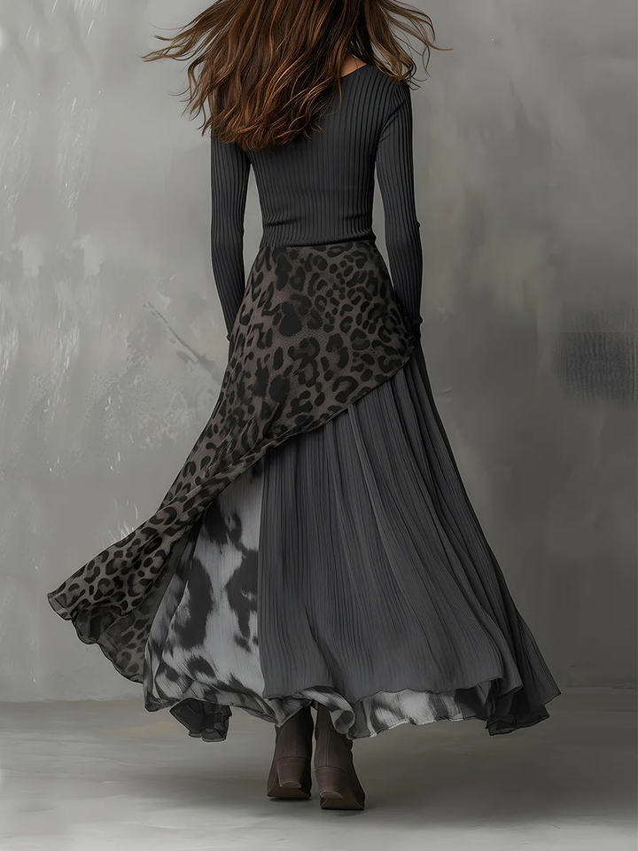Back view of gray maxi dress with animal print, flowing skirt, model standing in studio.