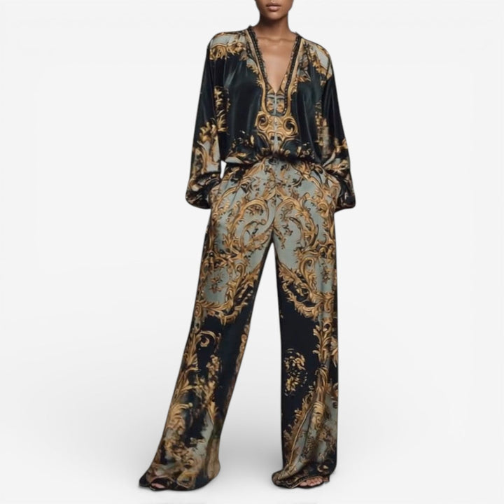 Elegant printed set with a deep V neckline and flowing wide-leg pants in a baroque pattern, modeled against a plain white background.