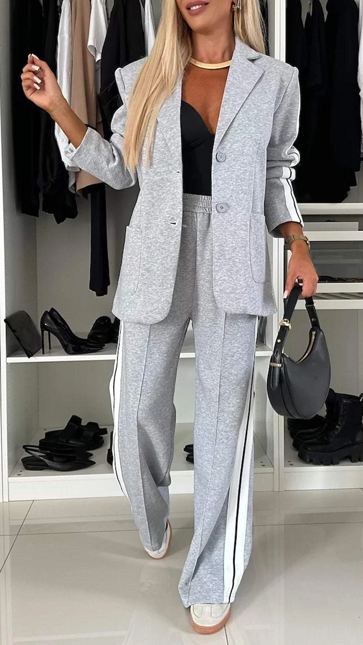 Grey casual office suit with white stripes displayed in a wardrobe setting with black high heels.