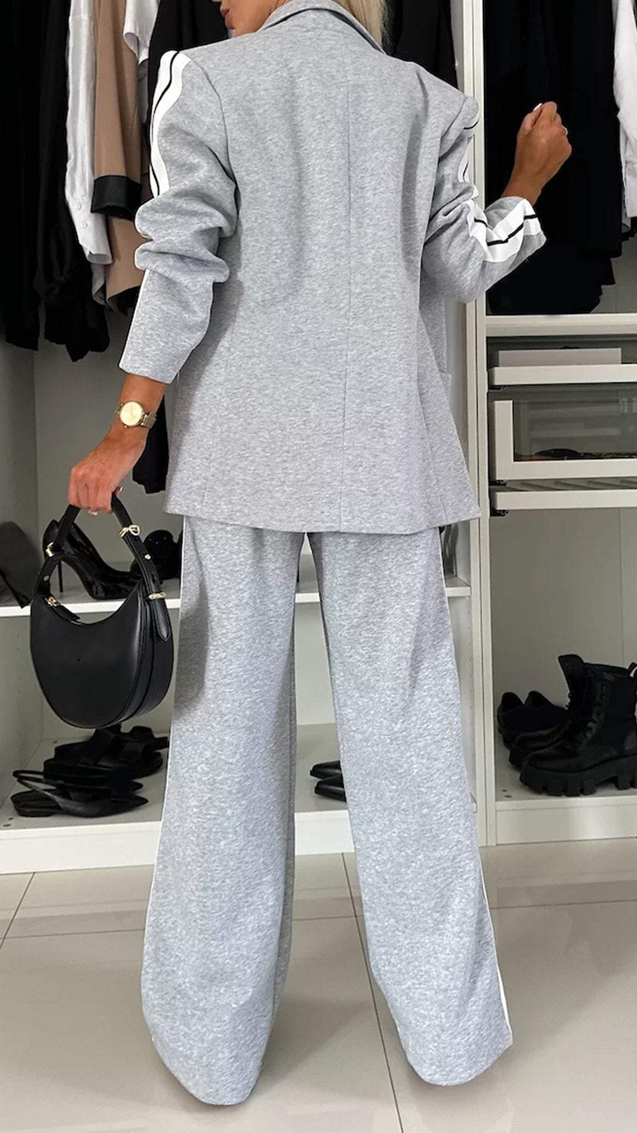 Back view of grey office suit with stripes, modeled in a wardrobe setting.