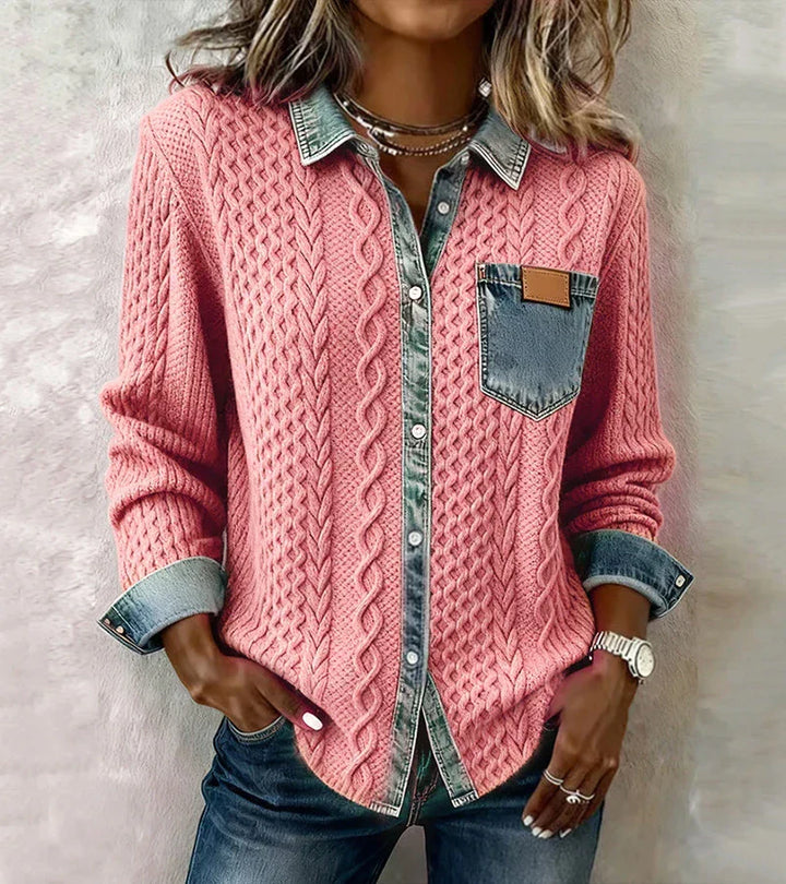 Person wearing a pink knit top with denim accents, positioned against a textured gray backdrop.