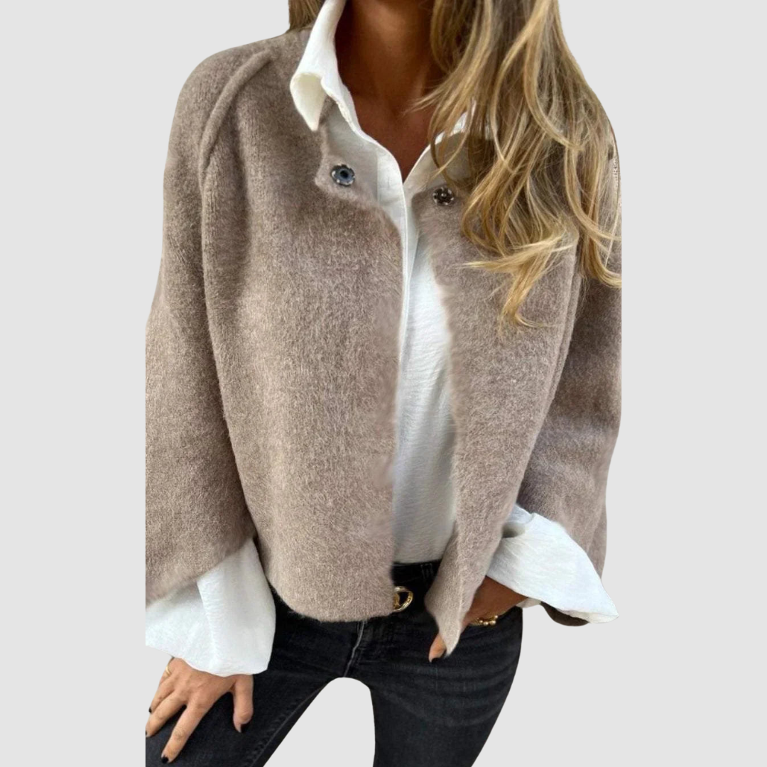 Soft, light brown spring coat over a white shirt on a person, worn with black jeans, studio background.