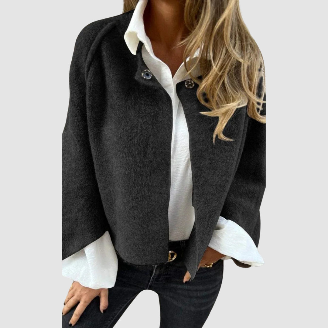 Soft, charcoal gray spring coat over a white shirt on a person, worn with black jeans, studio background.