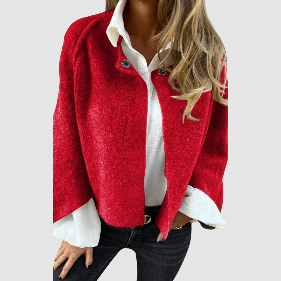 Soft, vibrant red spring coat over a white shirt on a person, worn with black jeans, studio background.
