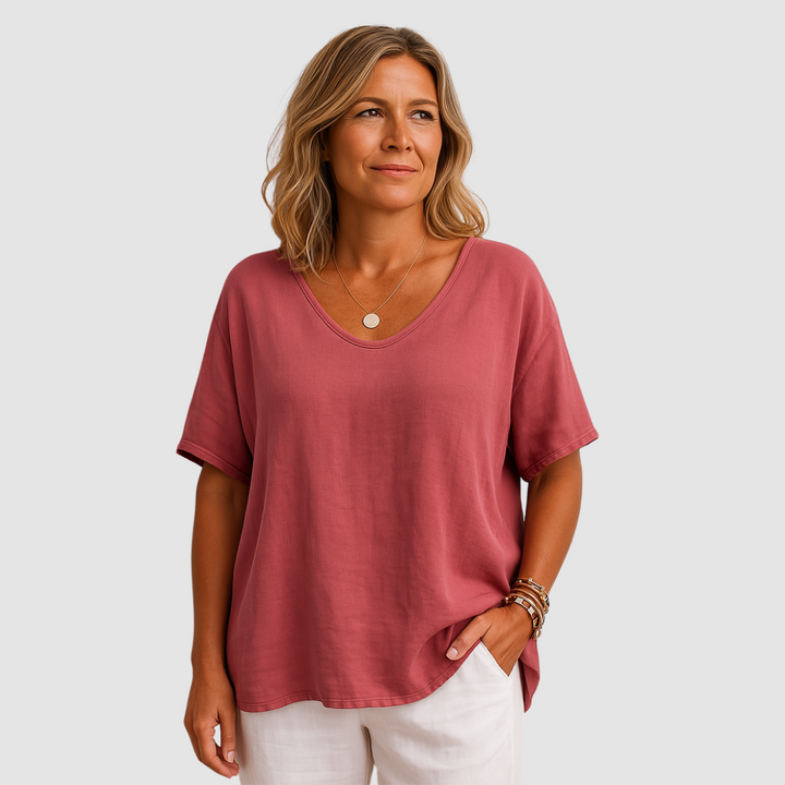 Woman dressed in a loose fit pink t-shirt with white shorts in a studio environment.