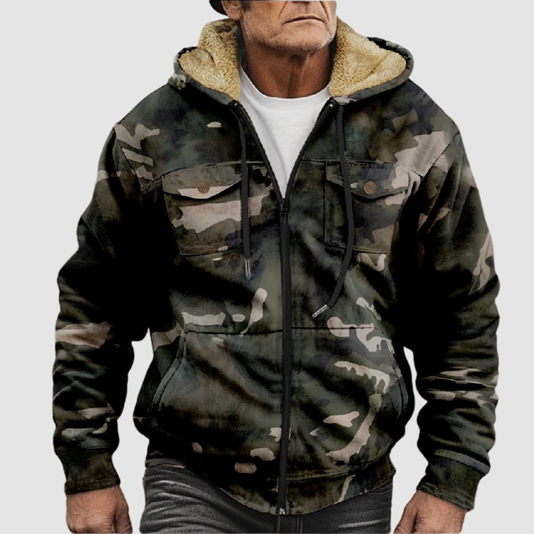 Camouflage jacket with furry hood lining, front pockets, and zip closure worn by a model against a light gray background.
