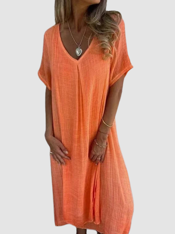 Orange V-neck dress with short sleeves, worn by a person in a neutral studio setting.