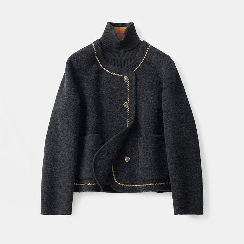 Black cashmere coat with decorative trim and buttons, layered over a dark turtleneck, on a white background.