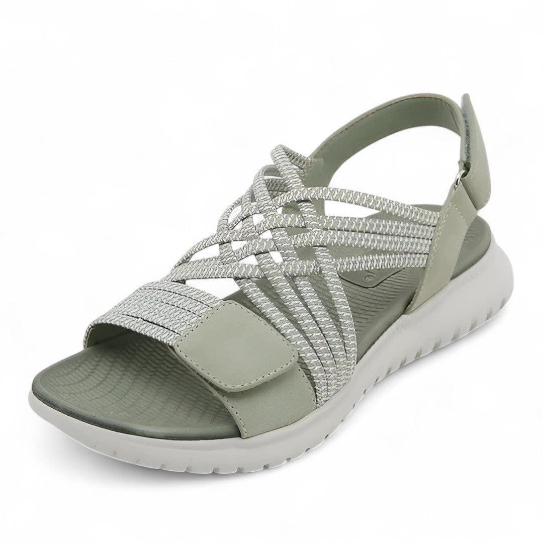 Light green orthopedic comfort sandal with crisscross straps, displayed in a studio setting.