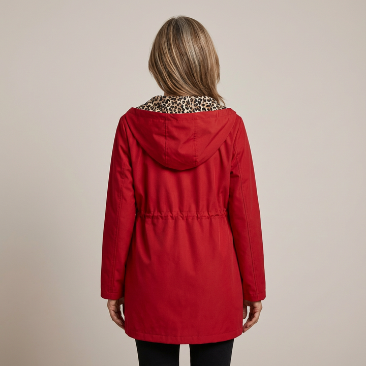 Back view of woman wearing red hooded coat with leopard print collar, studio setting.