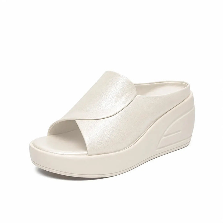 Off-white orthopedic slip-on wedge sandal with a sleek design, showcased in a studio environment.