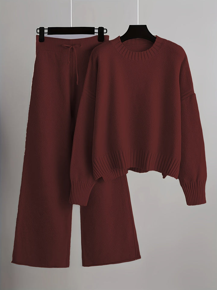 Burgundy knit loungewear set with a warm sweater and wide-leg pants on hangers, gray background.