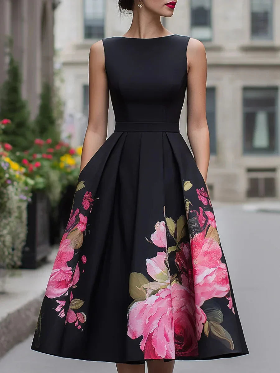 Elegant black midi dress with vibrant pink floral pattern, worn by model in urban setting.