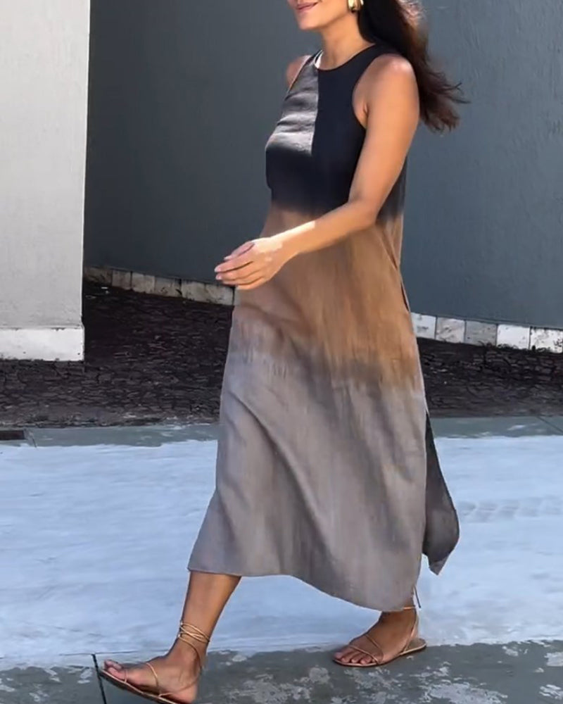 Woman wearing a sleeveless, ombre black to brown dress walking outside on a stone path.