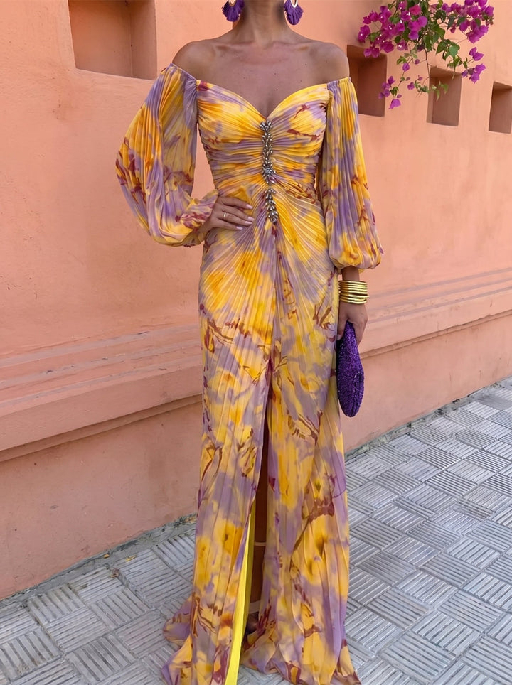 Close-up of a floral off-shoulder dress with jewel embellishments, set against an orange wall with flowers.