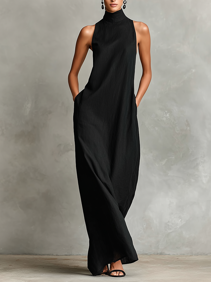 Black maxi dress with high neckline and sleeveless design, worn by a person in a studio setting.