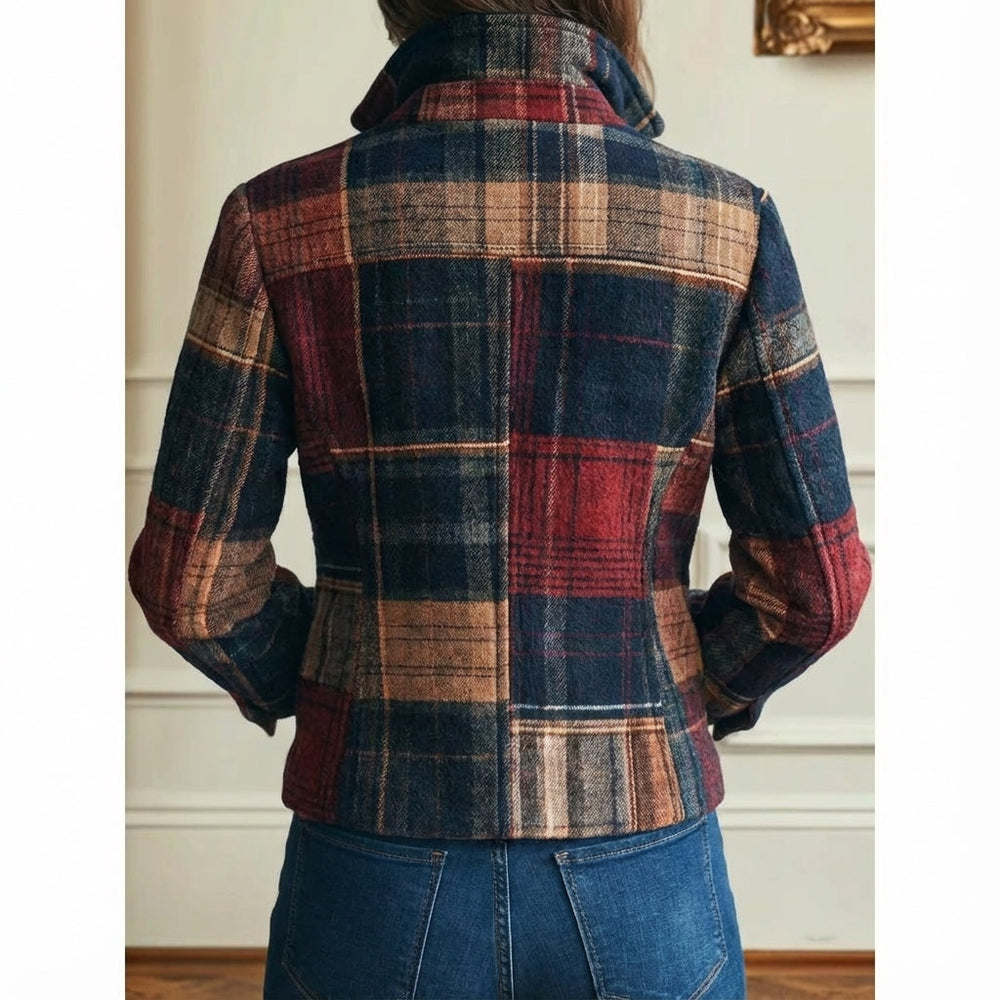 Back view of a classic plaid jacket in red and blue hues, paired with blue jeans. Indoor setting with a white wall.