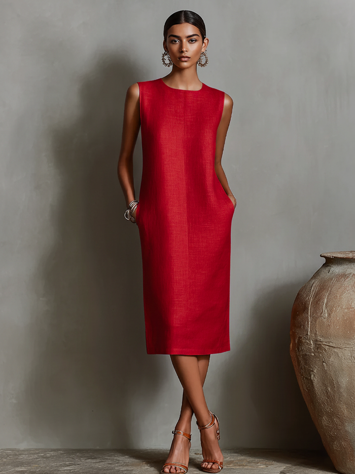 Red midi dress with pockets, sleeveless design, worn by model in elegant studio setting.