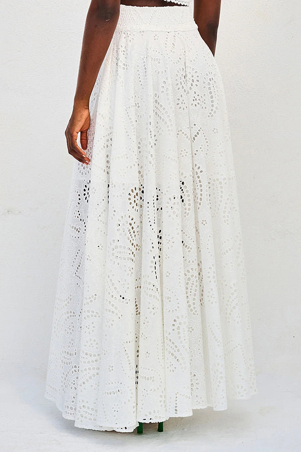 Back view of a white embroidered high-waist maxi skirt worn by a model against a neutral backdrop.