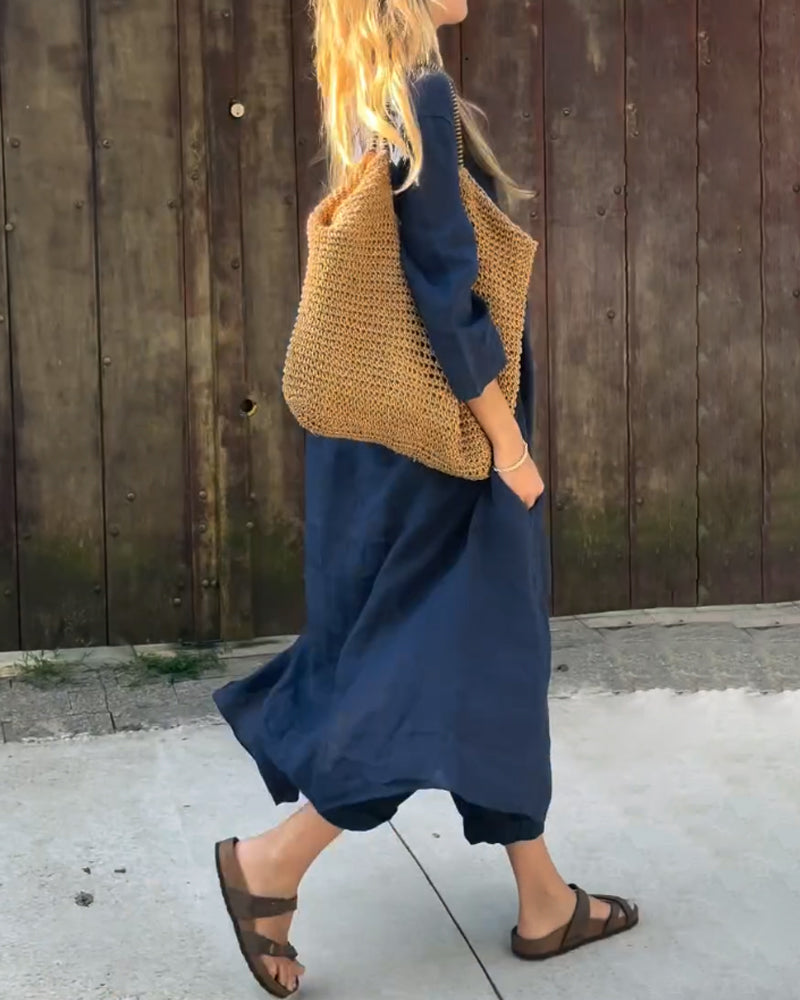 Side view of navy comfortable outfit and woven bag in outdoor setting.