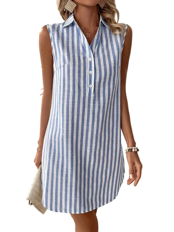 Front view of sleeveless blue and white striped shirt dress on model with bead accessories against a white background.