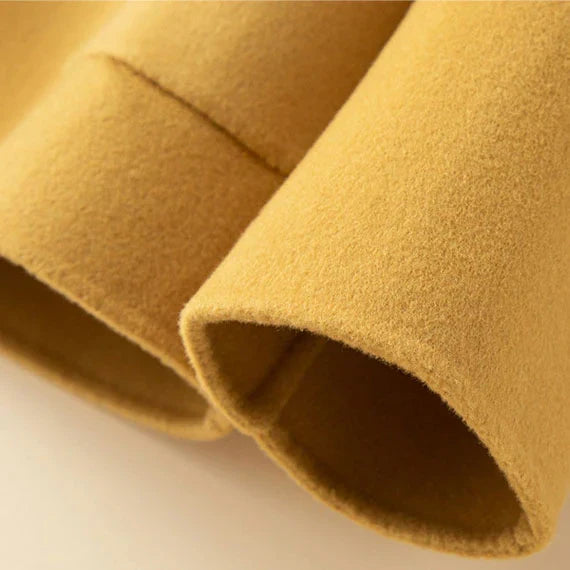 Close-up of yellow jacket sleeve with soft texture in a studio setting.