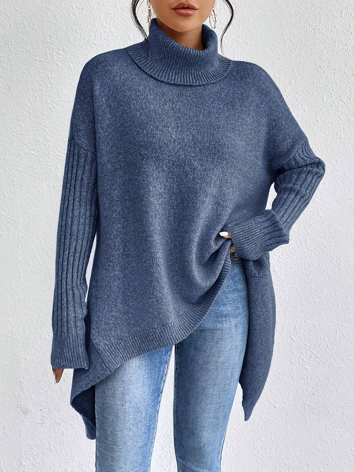 Blue sweater with turtleneck and long sleeves in textured knit, styled with jeans, against a white backdrop.