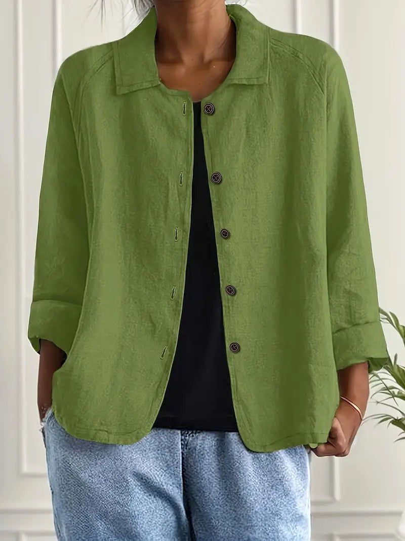 Bright green long sleeve top with button-down front, worn over a black shirt. Indoors, white paneled wall backdrop.
