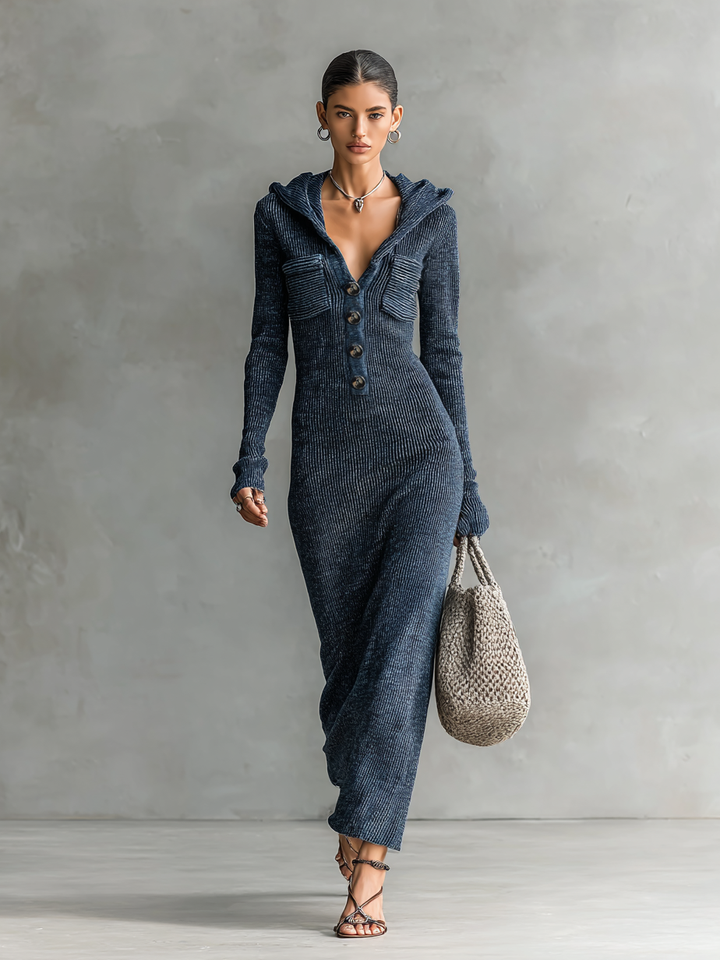 Full view of a woman in a dark blue hooded maxi dress with buttons wearing it stylishly against a neutral background.