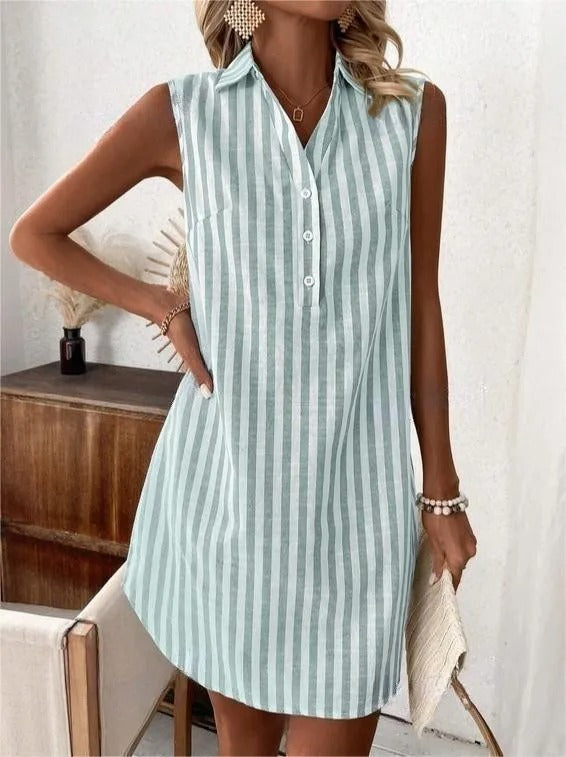 Green striped shirt dress with buttons, styled with jewelry and a clutch, in a homey interior space with simple decor.